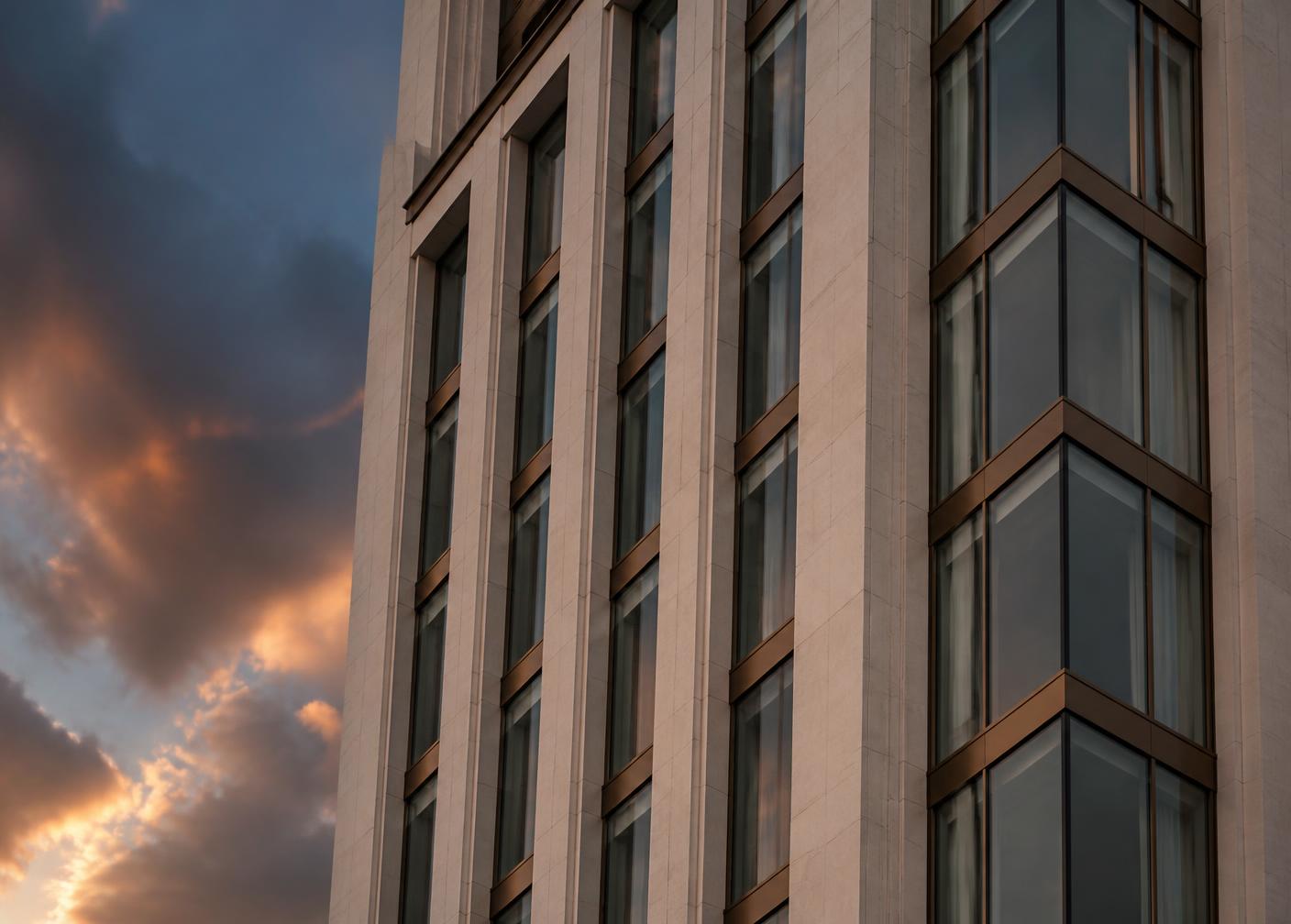 Modern residential tower facade with limestone piers and bronze mullions